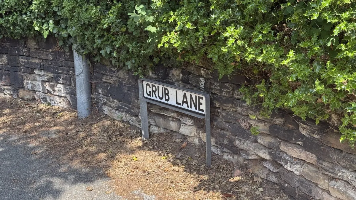 Grub Lane sign on an old sandstone wall in Kelsall